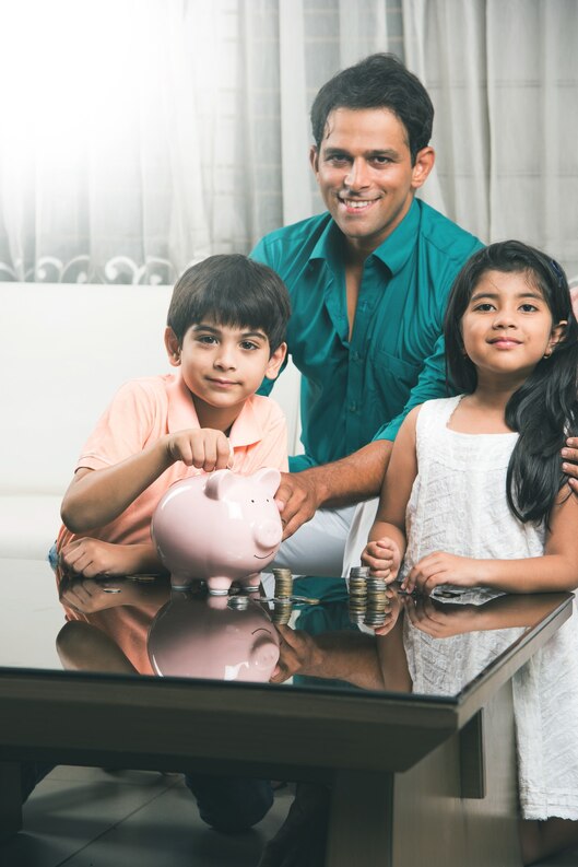 [freepicdownloader.com]-smart-indian-asian-couple-teaching-importance-saving-kids-home-with-piggy-bank-medium.jpg